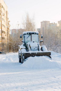 在寒冷的冬天街头被雪覆盖着的推土机