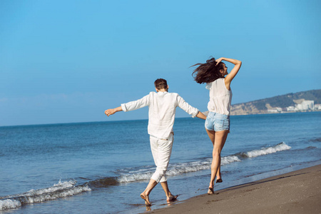 年轻夫妇走上海滩微笑