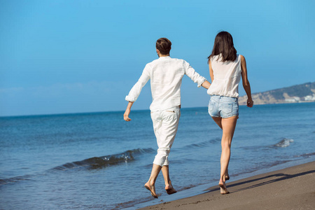 年轻夫妇走上海滩微笑