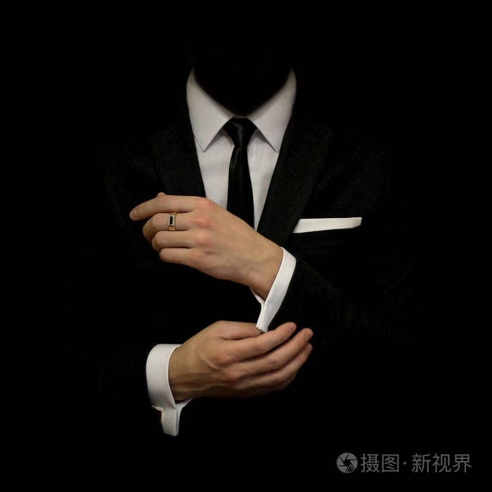 黑色西装和白色衬衫和黑色背景上的黑色领带的人.没有一张脸.