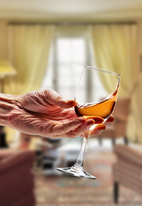 在玻璃在豪华的客厅里打旋的桃红葡萄酒