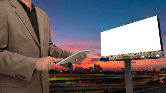 商人用空白广告牌在 twilig 的手机或平板电脑