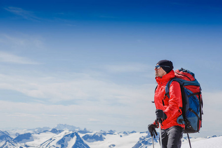 徒步旅行者站在一座山的顶上和享受上层视图的背包