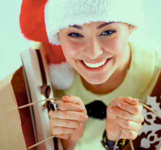 微笑在圣诞老人的帽子，与很多礼品盒白色背景上的女人