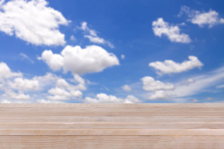 棕色木桌上散景抽象的蓝色天空背景