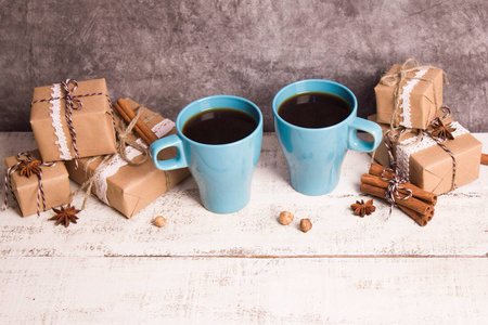 两只蓝色的咖啡杯，白色的木制背景上的礼物