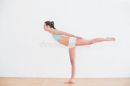 运动型女子单腿站立在健身中心