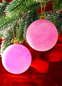 圣诞树树枝上的两个粉红色新年球