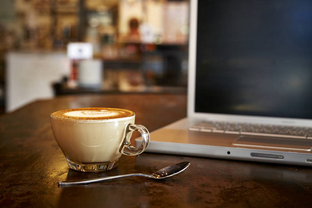 笔记本电脑与新鲜杯咖啡