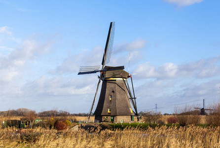 旧的 传统的风车在荷兰的运河。Netherlands.White 云在蔚蓝的天空，风在吹