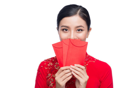 美丽的亚洲女性对传统节日的肖像服装 Ao Dai 握着红色的口袋压岁钱。春节假期。农历新年