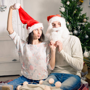 美丽的年轻夫妇，在圣诞老人的帽子微笑着庆祝 N