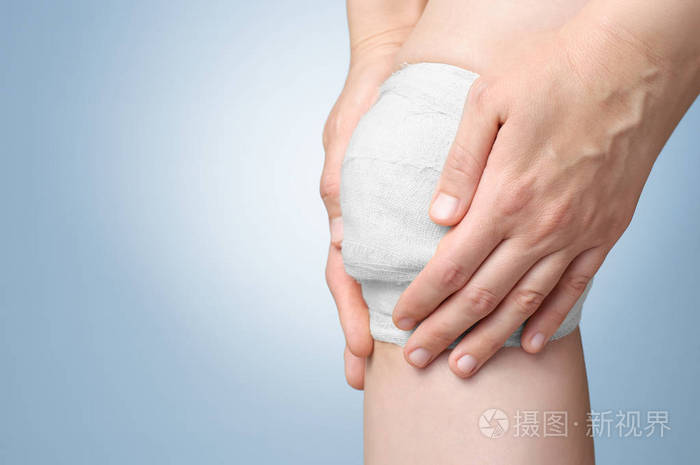 用绷带包扎受伤的膝盖