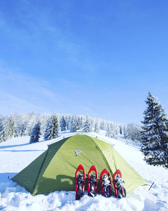 冬季徒步旅行。在山里徒步旅行带着背包和帐篷雪的冬天