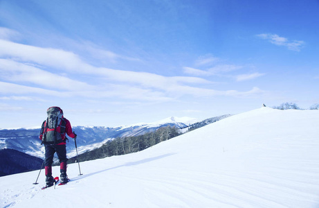 冬季徒步旅行。在山里徒步旅行带着背包和帐篷雪的冬天