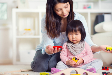 很高兴日本母亲玩她小小的蹒跚学步的女儿