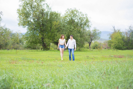 情人男人和女人走在绿色的田野