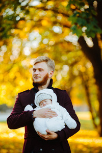爸爸和新生儿的儿子，在秋天的公园