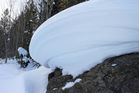 一个圆圆的雪堆坐落在巨石上图片