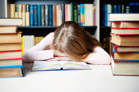疲倦的学生女孩睡在桌子上的书。教育 会话 考试和学校的概念