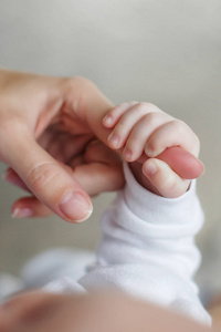 初生男婴抱着他母亲的手指