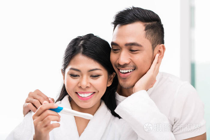 亚洲夫妇怀孕测试在床上