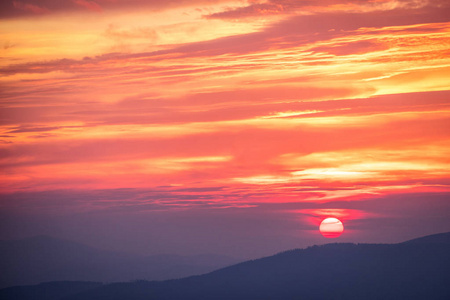 红色的夕阳在山景观与明媚的光芒。戏剧性的一幕