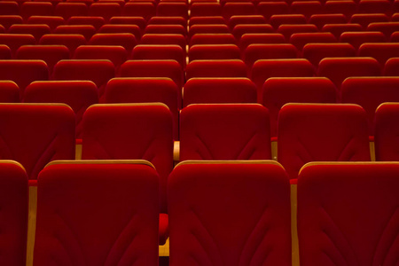 在电影院里无人的空红色椅子