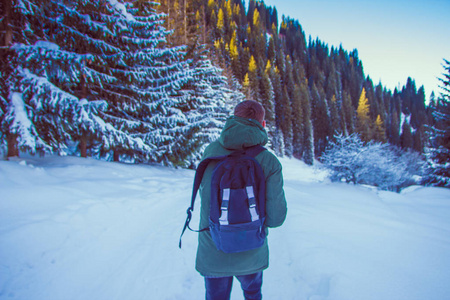 背包的年轻人走在冬天山。回到 vie