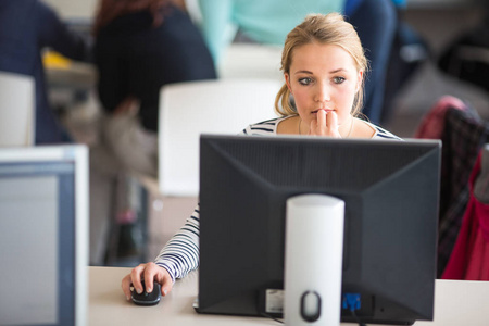 漂亮的女学生看着桌面计算机屏幕，lea