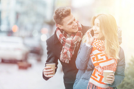 年轻美丽的夫妇在冬天在大街上玩。热恋中的情人节的情侣