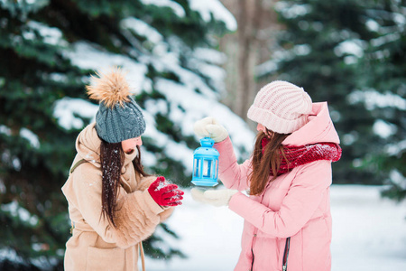 美丽的冬天在户外举行圣诞烛光的年轻女孩下雪天和温暖的手