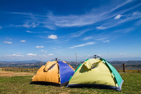 在白云和蓝天下的草地上，帐篷