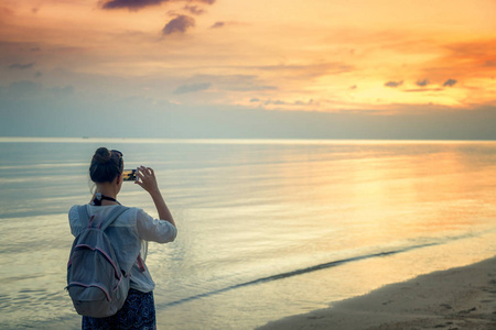 热带海滩日落启德岸上的年轻女人旅行者