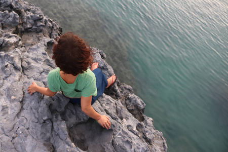女人站在海边的岩石上