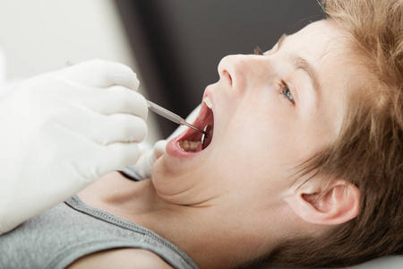 年轻的男孩牙齿检查由牙医