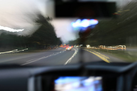 道路夜景从里面车天然光街道和其他汽车是运动模糊，模糊图像从里面一辆车行驶在夜间