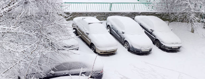 居民区停车场被雪覆盖的汽车图片