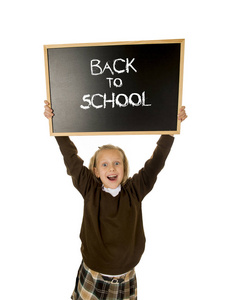 女学生微笑快乐控股和显示小黑板上用文本回到学校