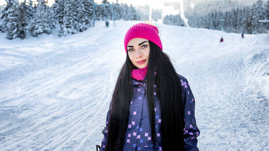 女孩滑雪板站冬季滑雪坡微笑和看