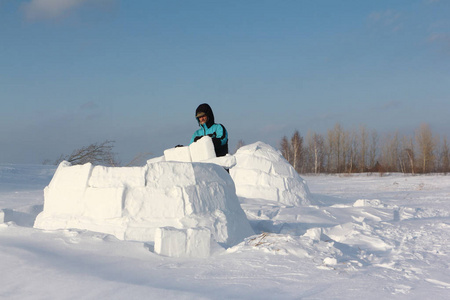 人在冬天盖一座冰屋的林间空地上的雪块