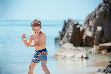在热带海滩上玩耍的 7 岁的可爱男孩