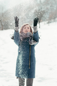 可爱的年轻女子，玩雪