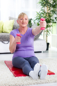 老年妇女在家举重锻炼
