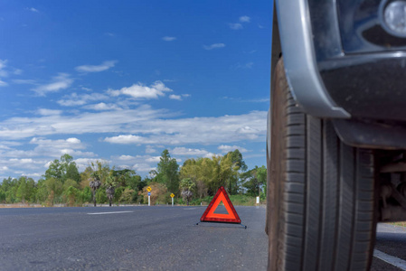 红色紧急停止标志和在道路上的破的车