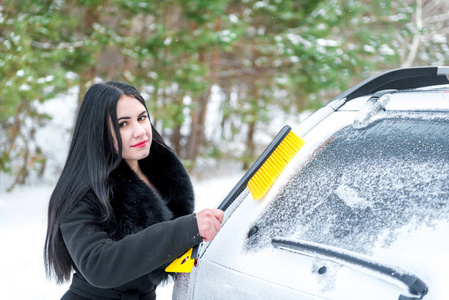 清洗的雪冬天快乐年轻刮板汽车挡风玻璃上的女人