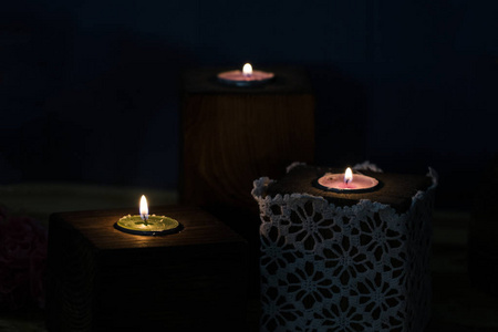 一个白色的蜡烛与深色背景在一个木制的烛台
