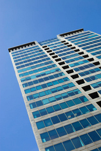 现代玻璃摩天大楼映衬在蓝天下