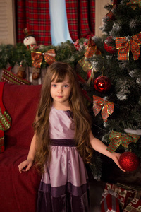 用流动的女孩头发在淡紫色的衣服站附近圣诞 tr