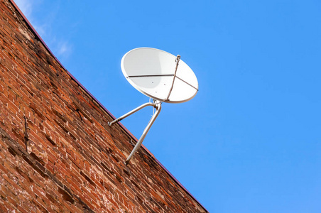 碟型卫星天线安装在垃圾砖房子的墙上